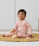 Infant sitting wearing ergoPouch Long Sleeve Romper 1.0 TOG Daisies