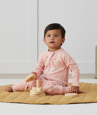 Infant sitting wearing ergoPouch Long Sleeve Romper 1.0 TOG Daisies