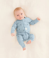 A baby is lying in a neutral color blanket wearing an ergoPouch Long Sleeve Romper in Dragonflies.