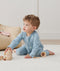Infant sitting wearing ergoPouch Long Sleeve Romper 1.0 TOG Dragonflies