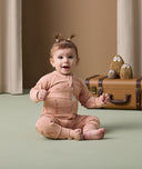 Infant sitting cozy in ergoPouch Long Sleeve Romper 1.0 TOG Elephant Parade