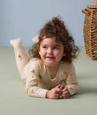 Little girl lying flat on its stomach wearing ergoPouch Long Sleeve Romper 1.0 TOG Savannah