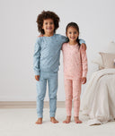 Two children embracing wearing ergoPouch Long Sleeve Pajamas 2.0 TOG Dragonflies, TOG rated pajamas for extra warmth
