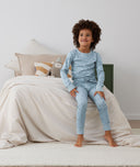 Child sitting on a bed in long-sleeve-pajamas-1-0-tog-dragonflies