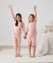 Two toddler holding hands in ergoPouch Short Sleeve Pajamas 0.2 TOG Daisies, perfect for the summer