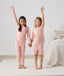 Two toddler holding hands in ergoPouch Short Sleeve Pajamas 0.2 TOG Daisies, perfect for the summer