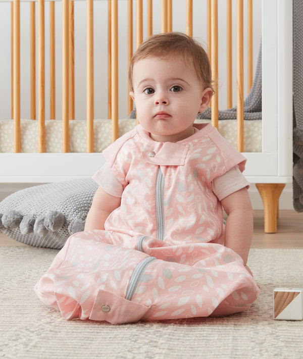 Infant wearing a pink premium sleep sack featuring a front zipper.