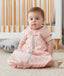Infant wearing a pink premium sleep sack featuring a front zipper.