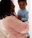 Mom wearing a an ergoPouch Matchy Matchy Robe Daisies, holding a child