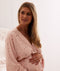 Mom wearing a an ergoPouch Matchy Matchy Robe Daisies, embracing her baby bump
