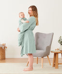 Mom holding baby wearing an ergoPouch Matchy Matchy Robe Sage