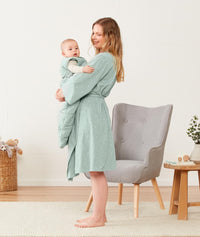 Mom holding baby wearing an ergoPouch Matchy Matchy Robe Sage
