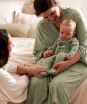 Mom wearing an ergoPouch Matchy Matchy Robe Willow, holding baby on lap in a matching romper