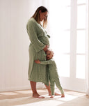 Toddler hugging the legs of a pregnant Mom, both wearing a matching ergoPouch sleepwear