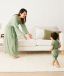 Mom wearing a an ergoPouch Matchy Matchy Robe Willow, reaching out for her toddler in matching sleepwear