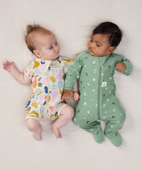 Two babies lying in ergoPouch Long Sleeve Romper 1.0 TOG Sweet Orchard and Fruit Salad