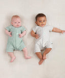 Babies lying in standing wearing a ergoPouch Short Sleeve Romper in Sage and Grey Marle