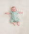 Baby lying wearing a ergoPouch Short Sleeve Romper in Sage