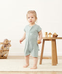 Toddler standing in ergoPouch Short Sleeve Romper in Sage