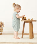 Toddler standing wearing a ergoPouch Short Sleeve Romper in Sage