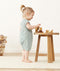 Toddler standing wearing a ergoPouch Short Sleeve Romper in Sage