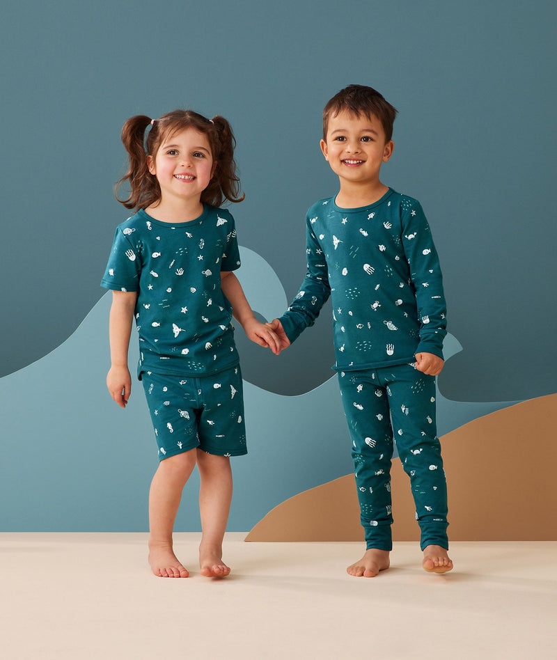 Two toddler holding hands in ergoPouch Short Sleeve Pajamas 0.2 TOG Ocean Blue, perfect for the summer