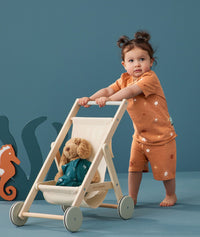 Child pushing a pram in ergoPouch Short Sleeve Pajamas 0.2 TOG Sunny