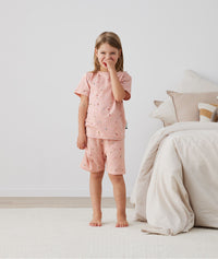 Toddler standing in ergoPouch Short Sleeve Pajamas 0.2 TOG Daisies, perfect for the summer