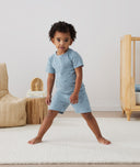 Toddler standing in ergoPouch Short Sleeve Pajamas 0.2 TOG Dragonflies, perfect for the summer