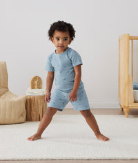 Toddler standing in ergoPouch Short Sleeve Pajamas 0.2 TOG Dragonflies, perfect for the summer