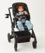 Child sitting in a pram wearing an ergoPouch Sleep Suit Sack 3.5 TOG Night Sky