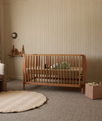 Baby lying in the new ergoPouch ellska Skye Crib, a promise of safety and serenity