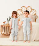 Two toddler holding hands in ergoPouch Sleep Onesie 1.0 TOG  and 0.2 TOG Grey Marle, perfect for the summer