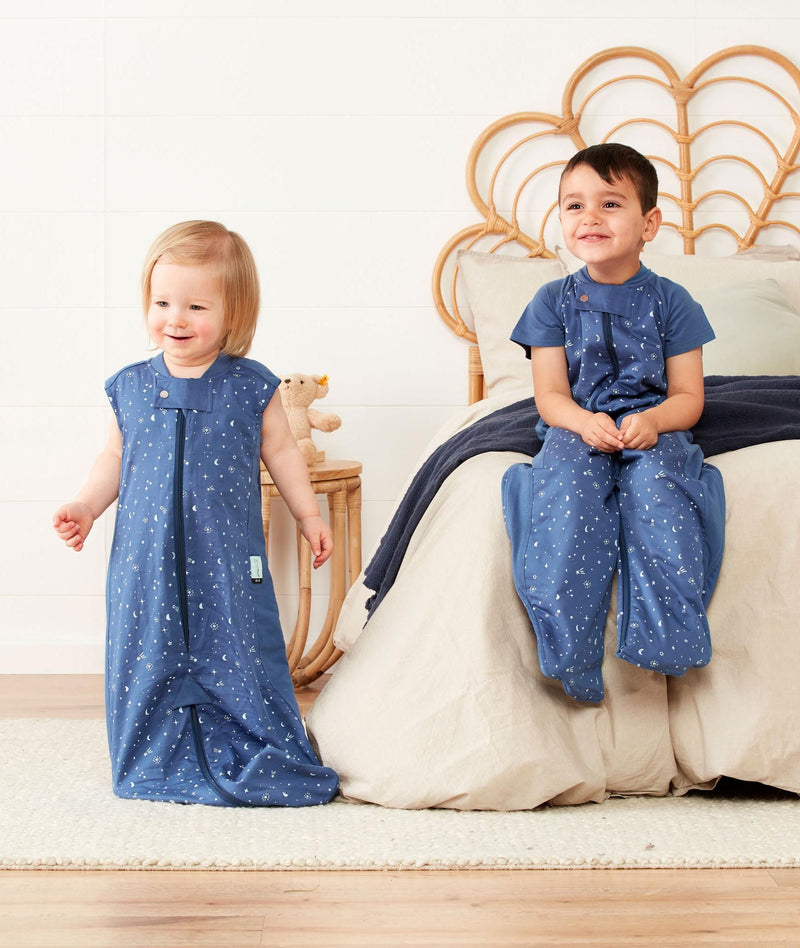Two children wearing a light ergoPouch Sleep Suit Sack 0.3 TOG Night Sky