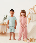 Toddlers wearing ergoPouch Short Sleeve Pajamas in Sage and ergoPouch Sleep Suit Bag in Berries