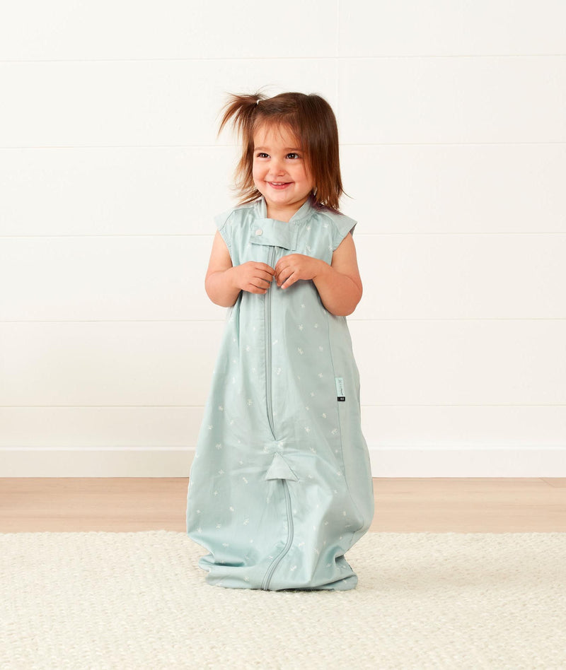 Smiling child in ergoPouch Sleep Suit Sack 0.3 TOG Sage, a sleep sack with legs