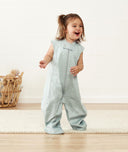 Smiling child in ergoPouch Sleep Suit Sack 0.3 TOG Sage, a sleep sack with legs