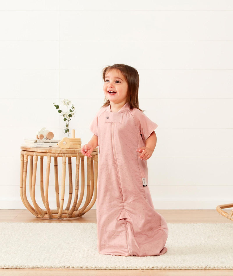 Smiling child in ergoPouch Sleep Suit Sack 1.0 TOG Berries, a sleep sack with legs