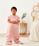 Child standing in ergoPouch Sleep Suit Sack 1.0 TOG Berries, a sleeping bag that converts to a sleeping bag with legs