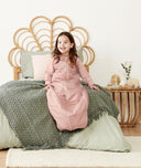 Child sitting in an ergoPouch Sleep Suit Sack 2.5 TOG Berries, a warm sleeping bag that converts to a sleeping bag with legs