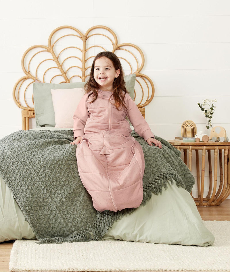 Child sitting in an ergoPouch Sleep Suit Sack 3.5 TOG Berries, a warm sleeping bag that converts to a sleeping bag with legs