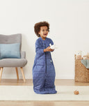 Child standing in an ergoPouch Sleep Suit Sack 3.5 TOG Night Sky, a warm sleeping bag that converts to a sleeping bag with legs