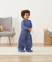 Smiling child in ergoPouch Sleep Suit Sack 3.5 TOG Night Sky, a warm sleep sack with legs