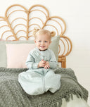 Toddler smiling wearing ergoPouch Sleep Suit Sack in Sage