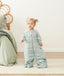 Smiling child in ergoPouch Sleep Suit Sack 2.5 TOG Sage, a warm sleep sack with legs