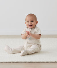 Infant sitting in ergoPouch Sleep Onesie 1.0 TOG Oatmeal Marle