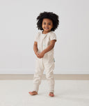 Toddler standing in ergoPouch Sleep Onesie 1.0 TOG Oatmeal Marle