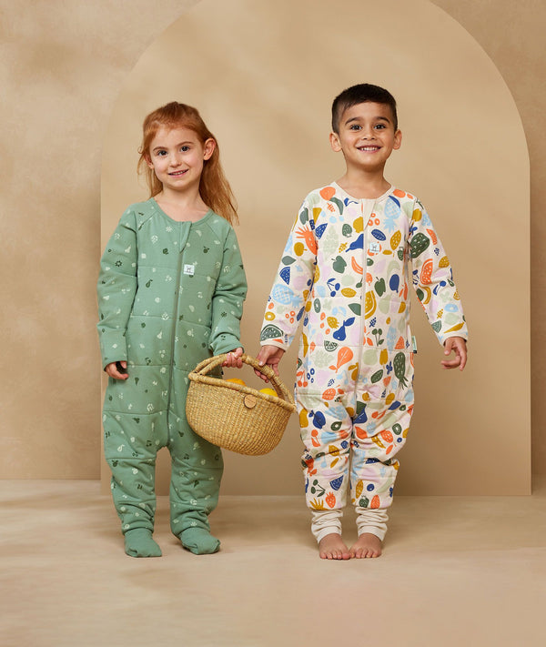 Two children playing in ergoPouch Sleep Onesie 2.5 TOG Fruit Salad, warm for the winter