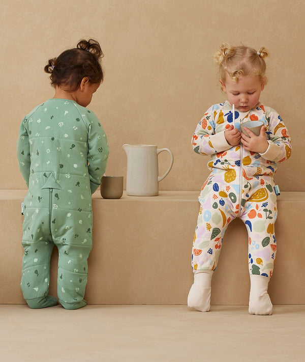 Two children playing in ergoPouch Sleep Onesie 2.5 TOG Sweet Orchard and Fruit Salad, warm pouch for the winter