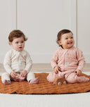 Two infants sitting in ergoPouch Sleep Onesie 2.5 TOG Daisies and Oatmeal Marle, warm for the winter